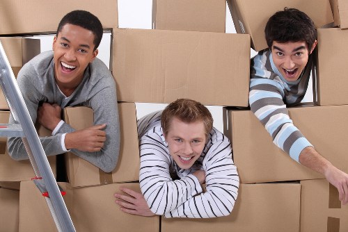 Moving team carrying household items through a Crystal Palace property